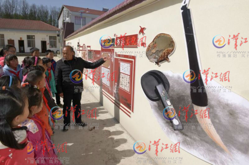 王老师向学生介绍书法文化墙。