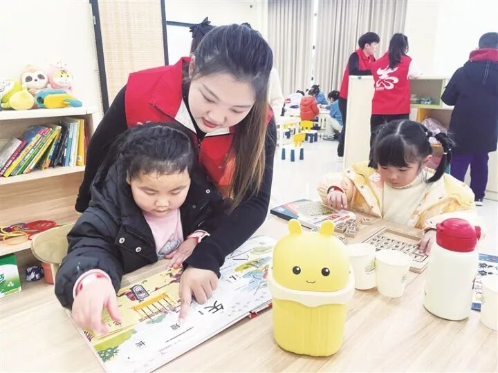 “锂想家”周末学堂爱心托管班志愿者与职工孩子共读绘本。 图片
