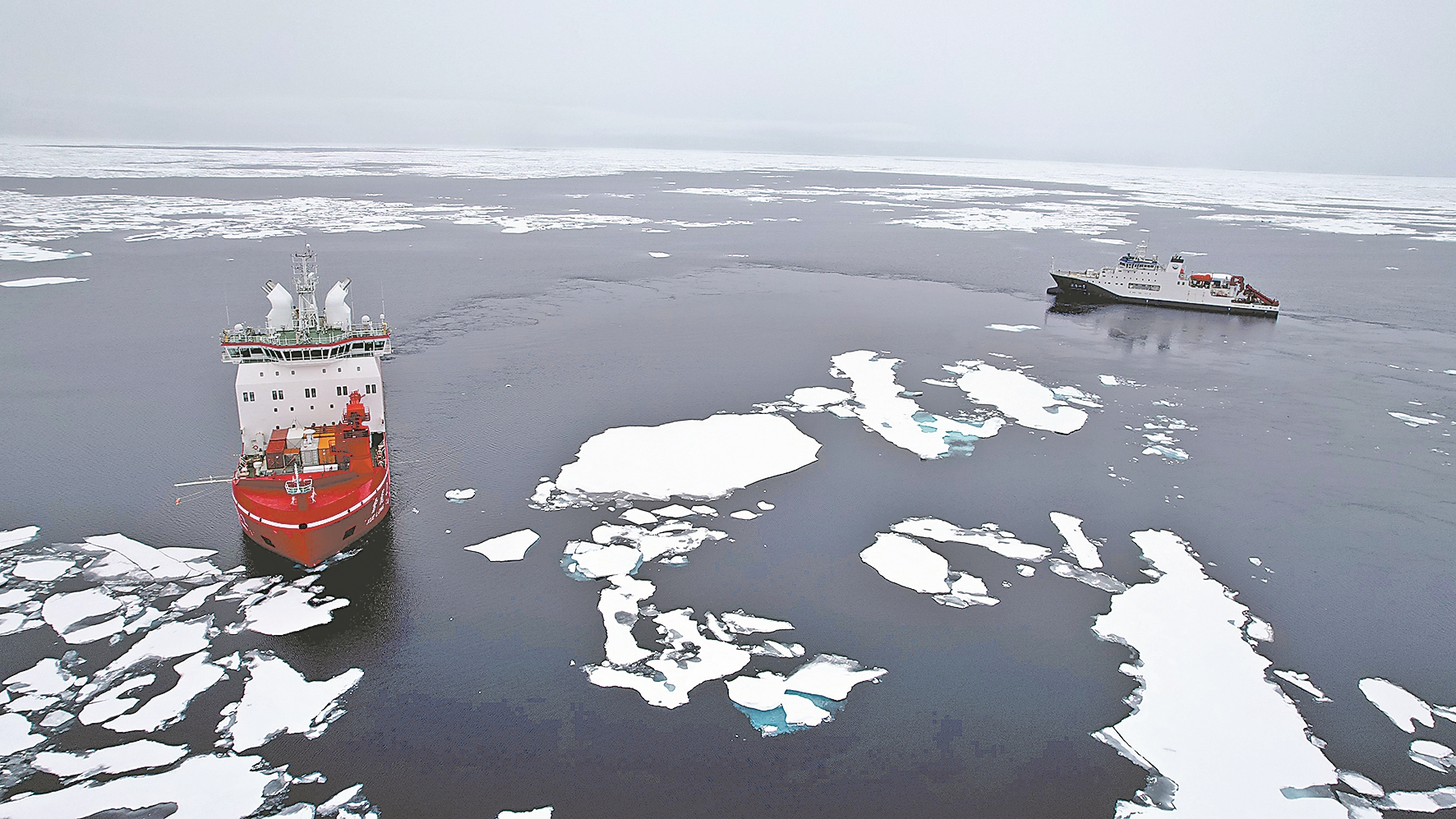 2025年8月11日,“雪龙2”号(左)在北极冰区为“深海一号”破冰引航(无人机照片)。新华社 发