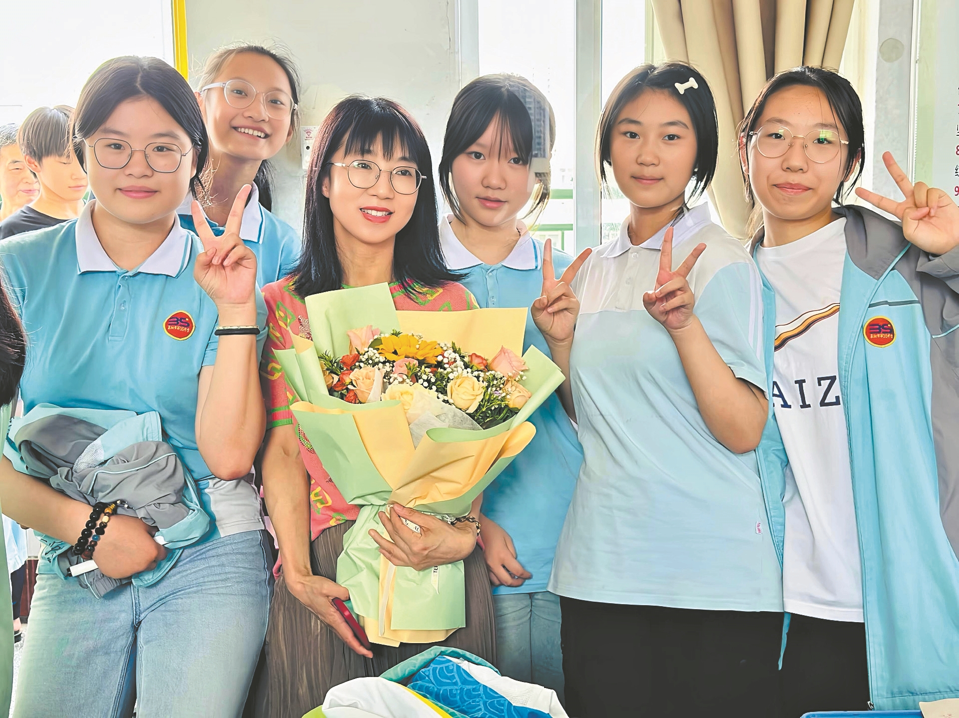 谢昌龄(持花者)与学生合影。