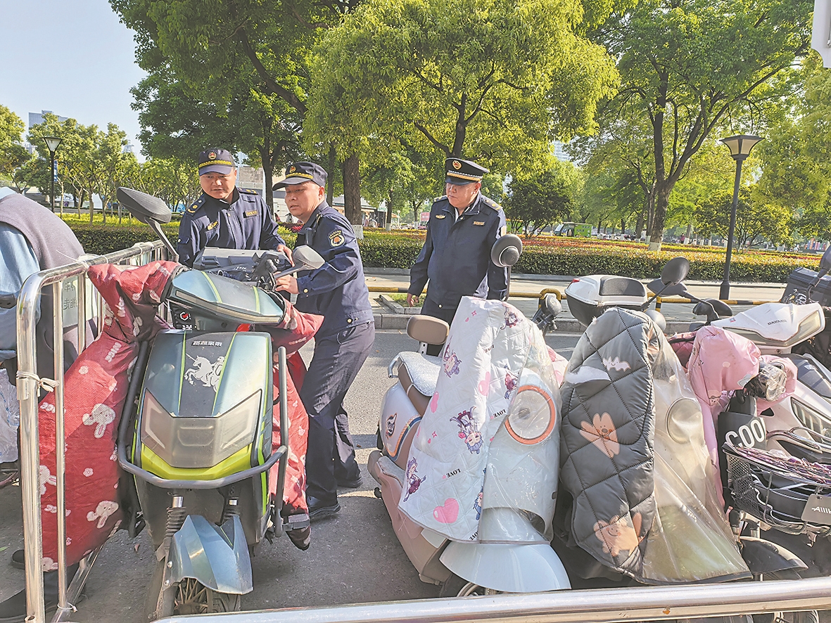宋仕成(中)与同事在维护“三车”停放秩序 记者陈莉莉 摄