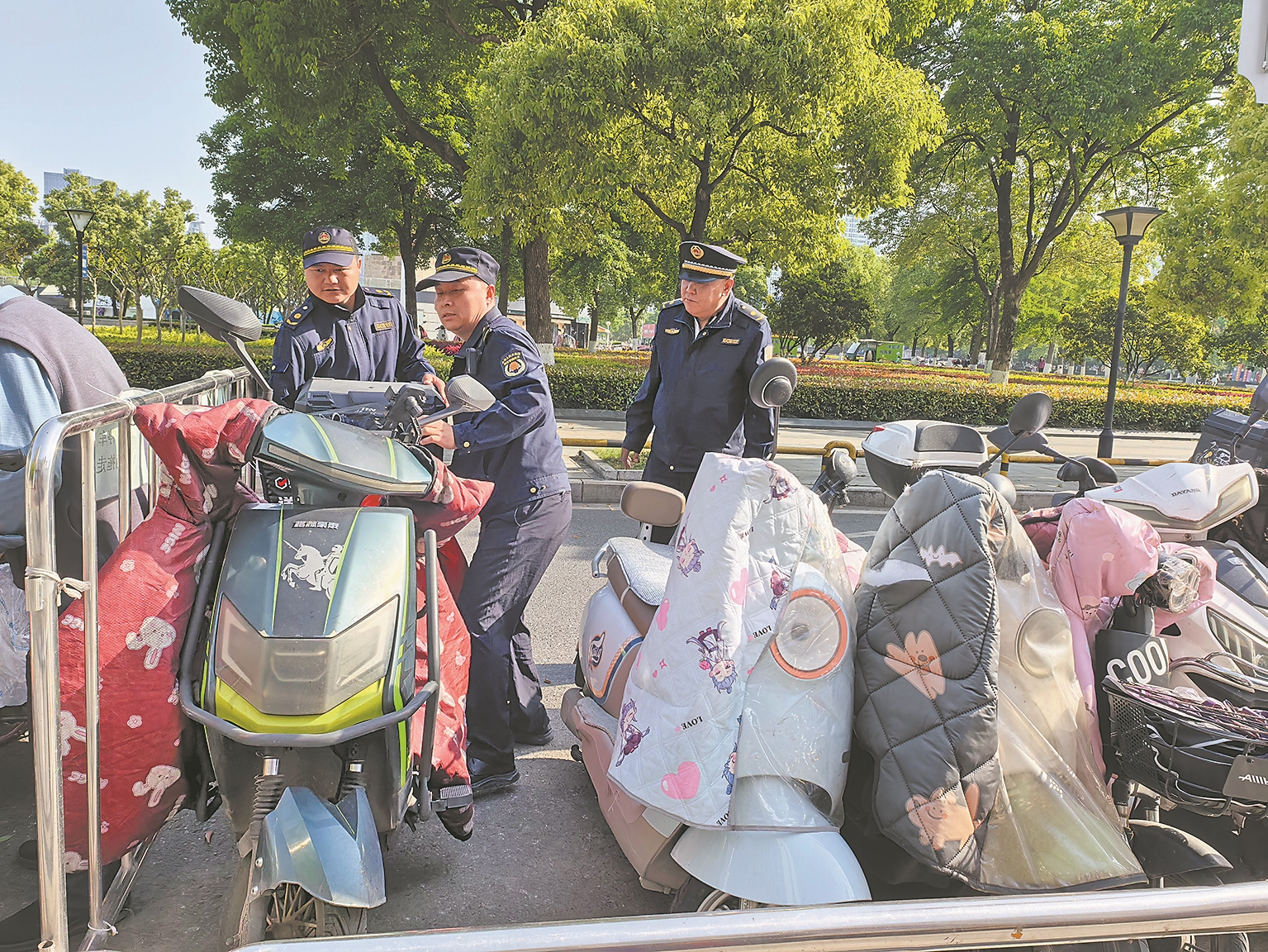 宋仕成(中)与同事在维护“三车”停放秩序。记者 陈莉莉 摄
