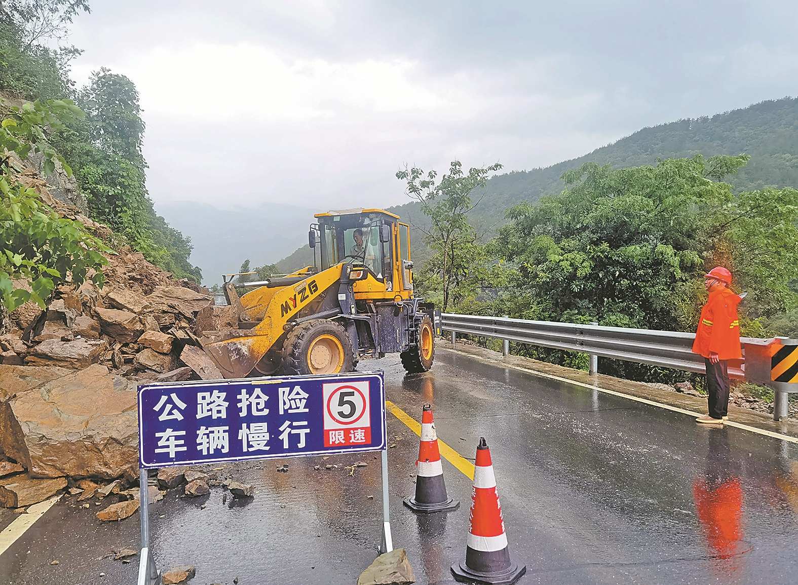 8月11日,在241国道保康县歇马镇羊五路段,公路养护工人操作大型工程机械处置路旁垮塌的石块。特约通讯员 陈泉霖 通讯员 肖婕 王满 摄