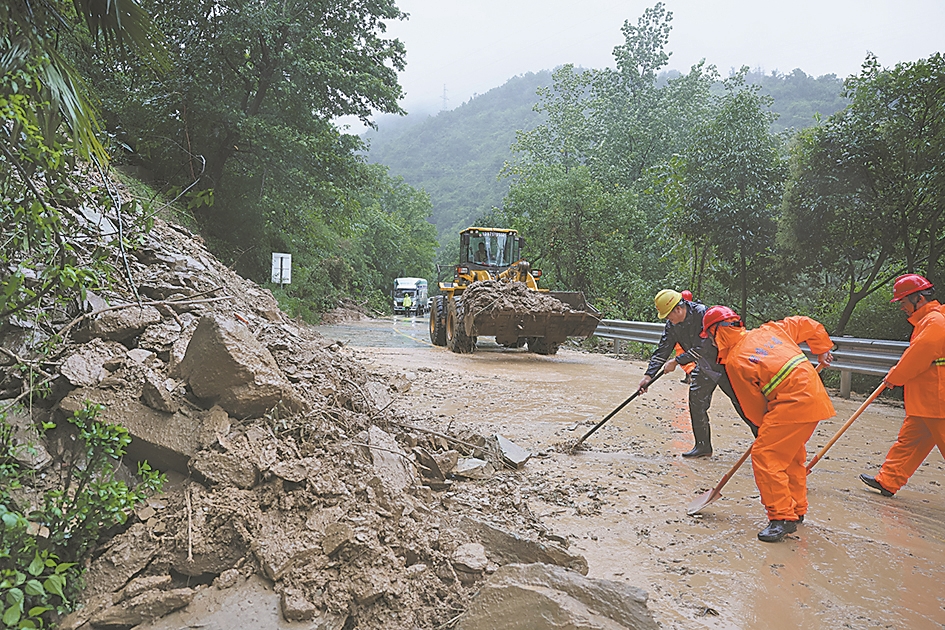 8月12日,在G241保康县过渡湾镇开峰峪路段,工作人员清理路面泥石,排除险情。记者 杨东 通讯员 陈泉霖 摄