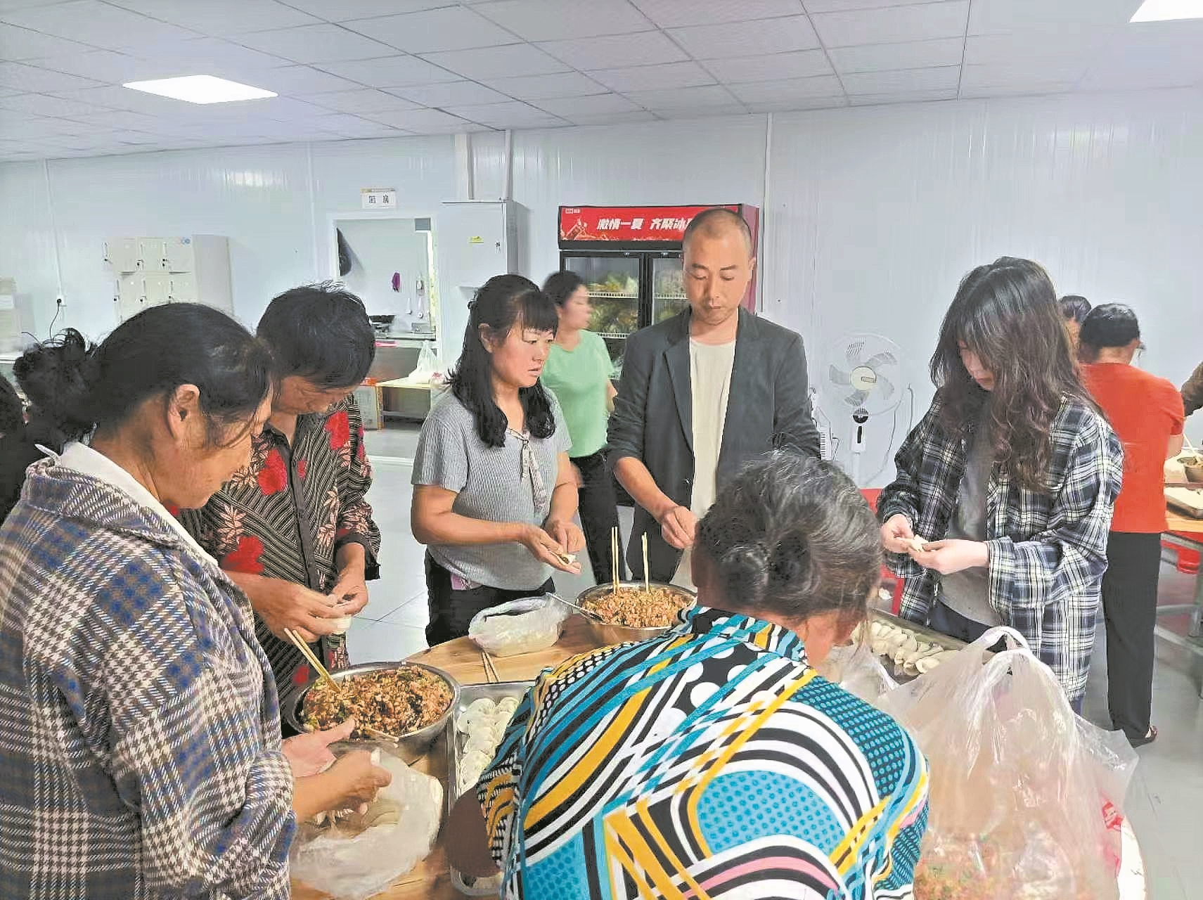 在安置点,朱飞与村民一起包饺子。记者 刘自航 通讯员 杨阳 摄