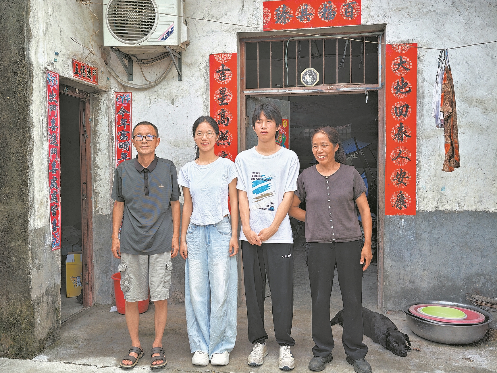 站在老屋前,孟平(左二)与父母、弟弟的合影