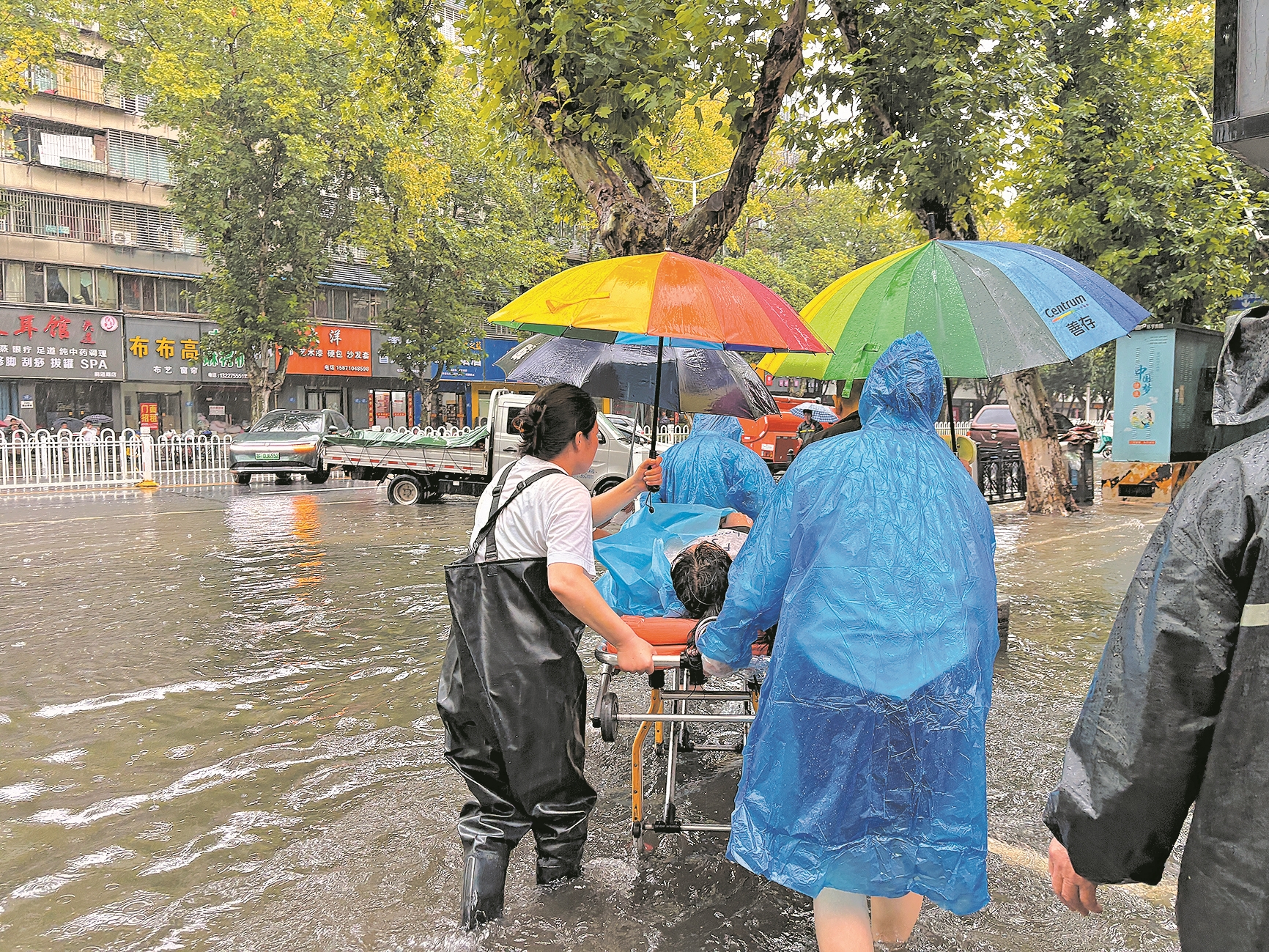 立业路社区工作人员冒雨转运病患 通讯员邓楠 摄