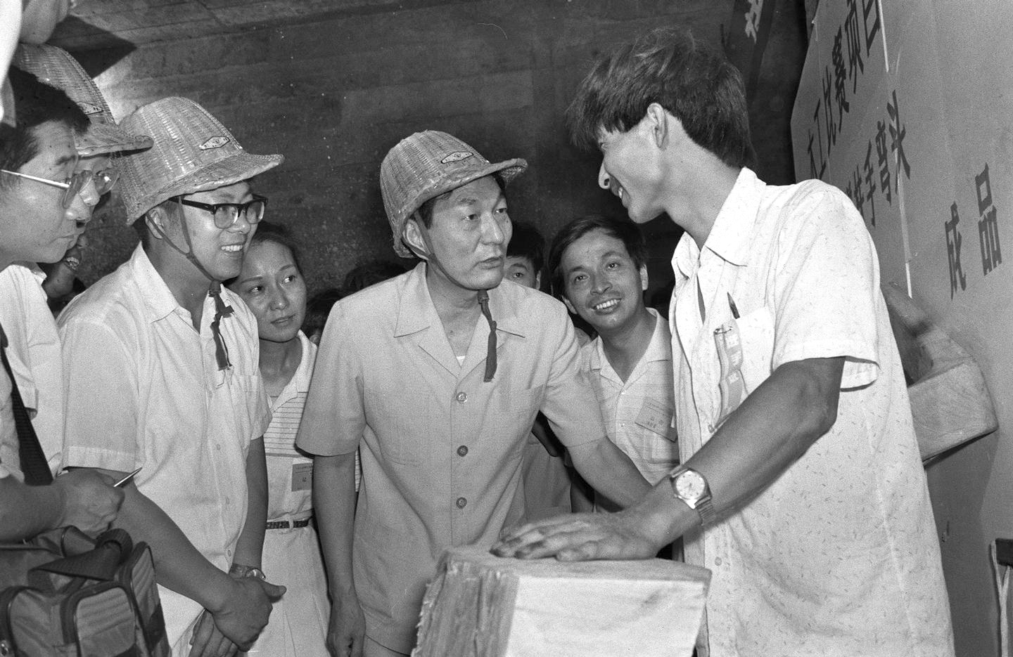 1990年,朱镕基同志看望参加上海青年技术比赛的工人。 新华社 发