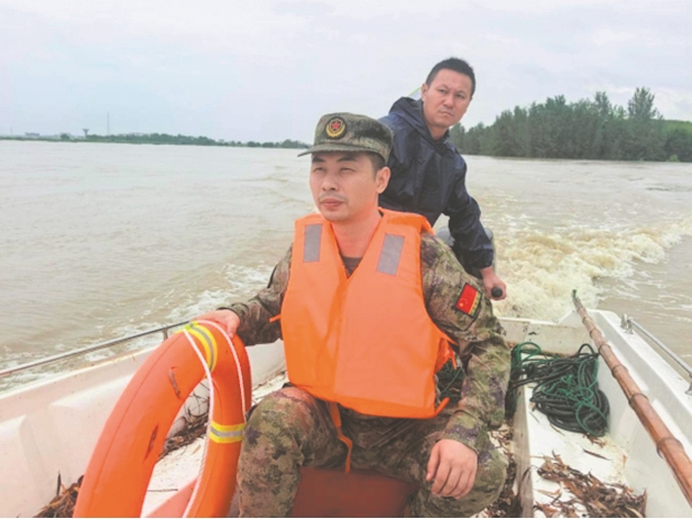 宜城市流水镇专武干部赴防汛一线转移受困群众和物资。