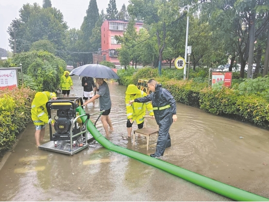 樊城区柿铺街道组织民兵在樊西实验小学排涝。