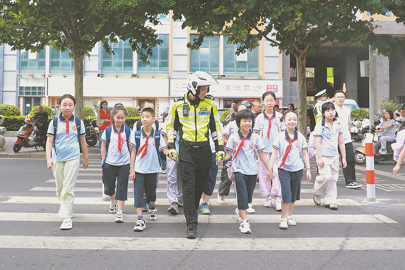 9月1日,交警护送红光小学学生安全通过斑马线。 记者 李旭晖 通讯员 梁政 贺傲然 摄
