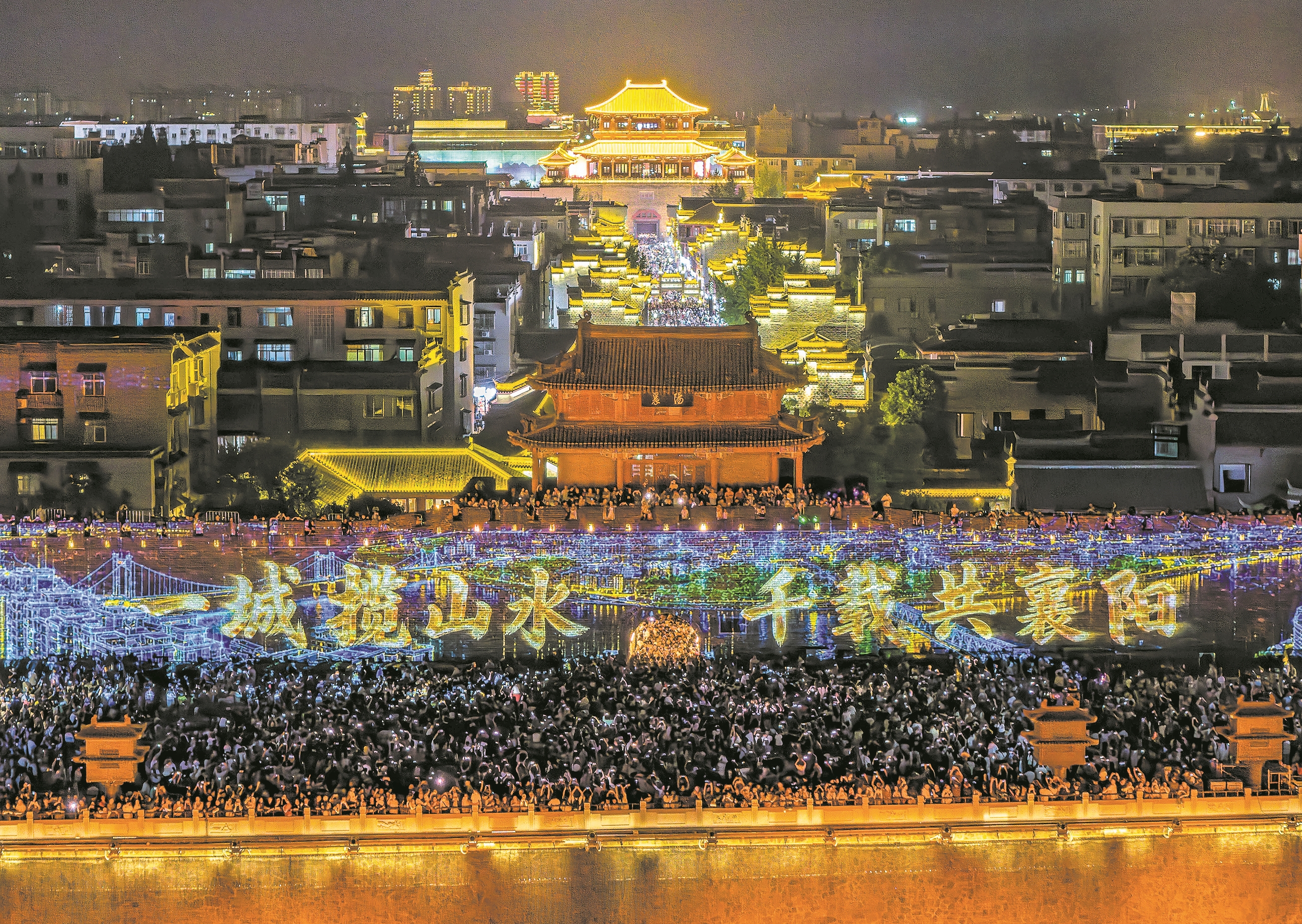 ↑市民和游客在襄阳古城小北门广场观看灯光秀。 记者 杨东 摄