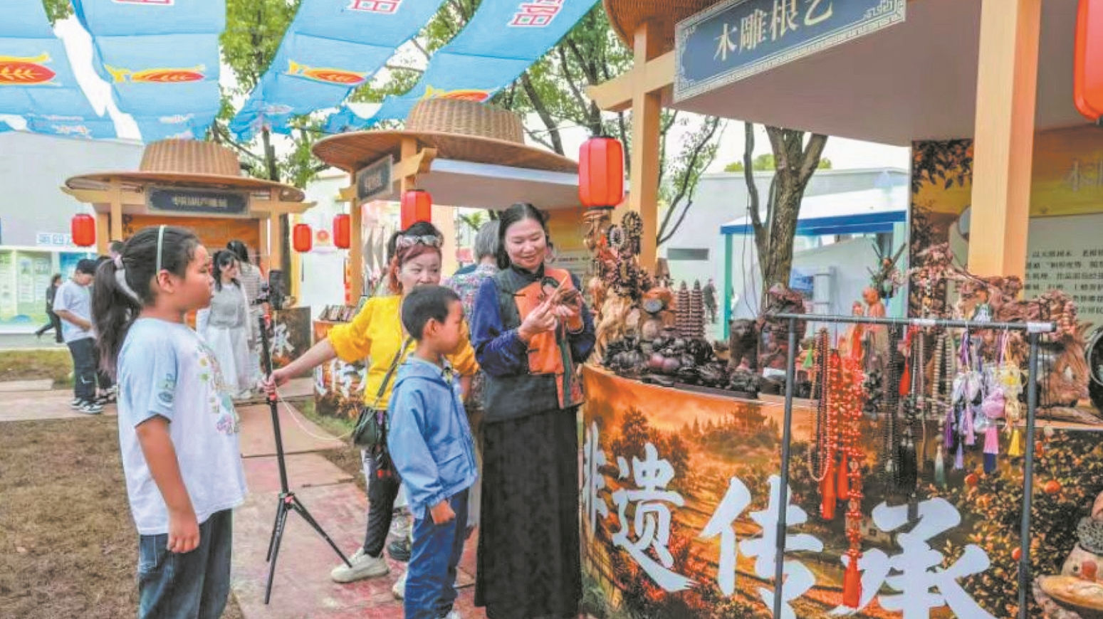 国庆假期,游客在木雕根艺展位前体验非遗魅力。通讯员 张艳峰 摄